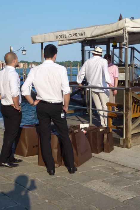 עובדי לואי ויטון משנעים סחורות ארוזות היטב למלונות הפאר הונציאנים ברציף ליד החנות